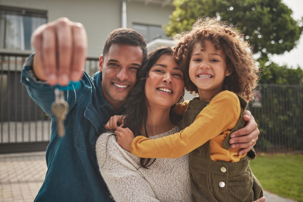 Happy family holding keys to their first home, smiling with excitement and anticipation for the future.